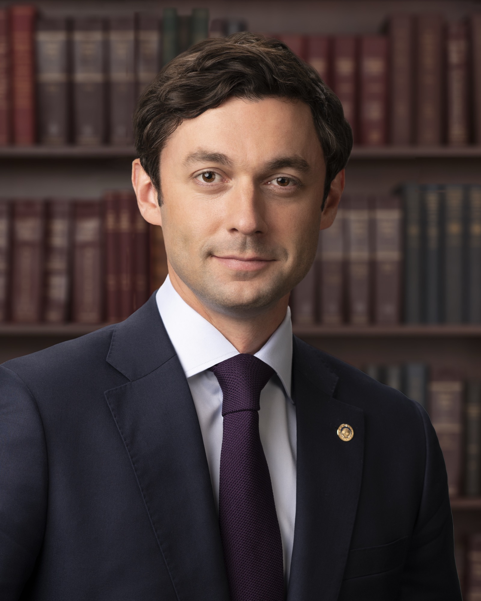 Official United States Senate portrait of Jon Ossoff in a dark suit and blue tie in front of an American flag
