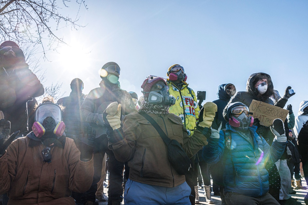 Law enforcement officers detaining a woman during protests in Minneapolis
